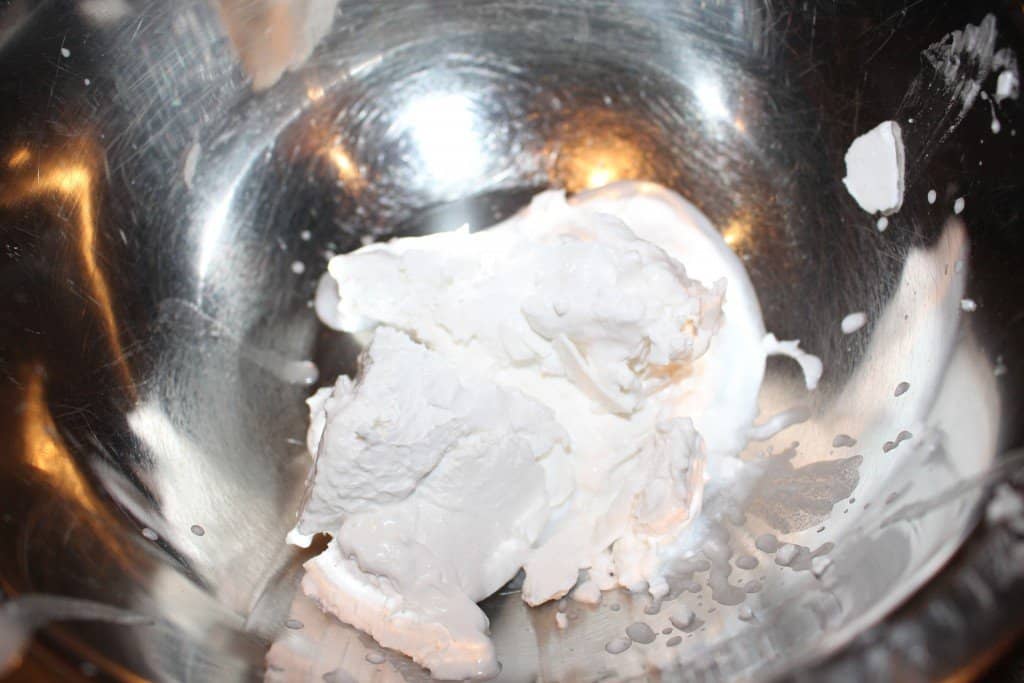 a large clump of coconut cream sitting in a stainless steel bowl