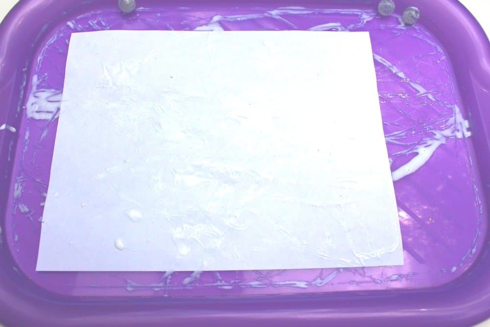 white paper with lines of white glue from rolling marbles