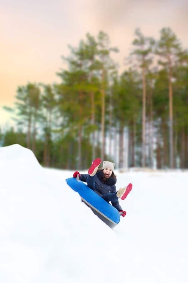 Woman snow tubing on a blue tube