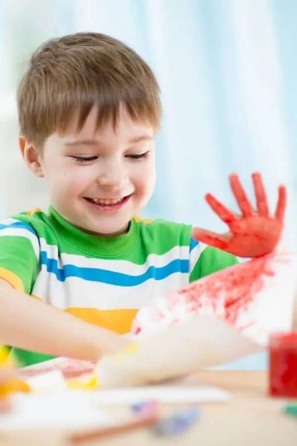 Brown haired boy finger painting at Maryville TN Daycares