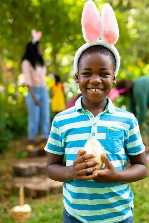 happy young boy holding a golden egg representing Easter egg hunts in maryville TN