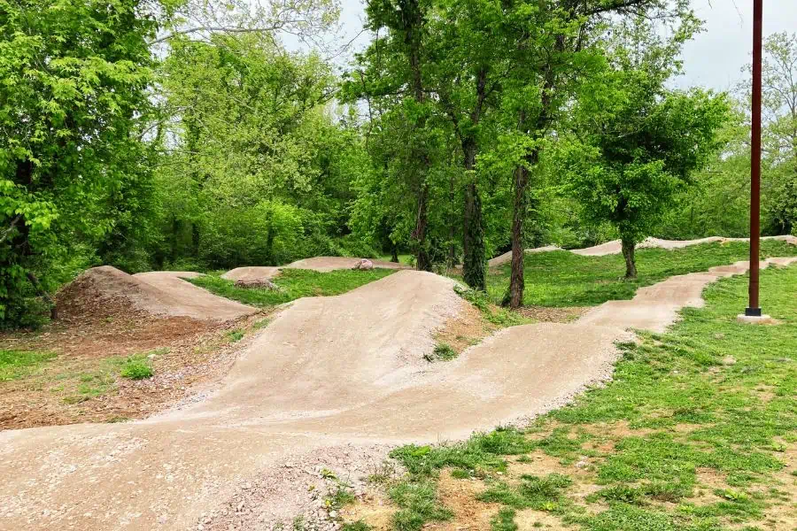 Dirt pump track surrounded by grass at Bakers  Creek Preserve in Knoxville.
