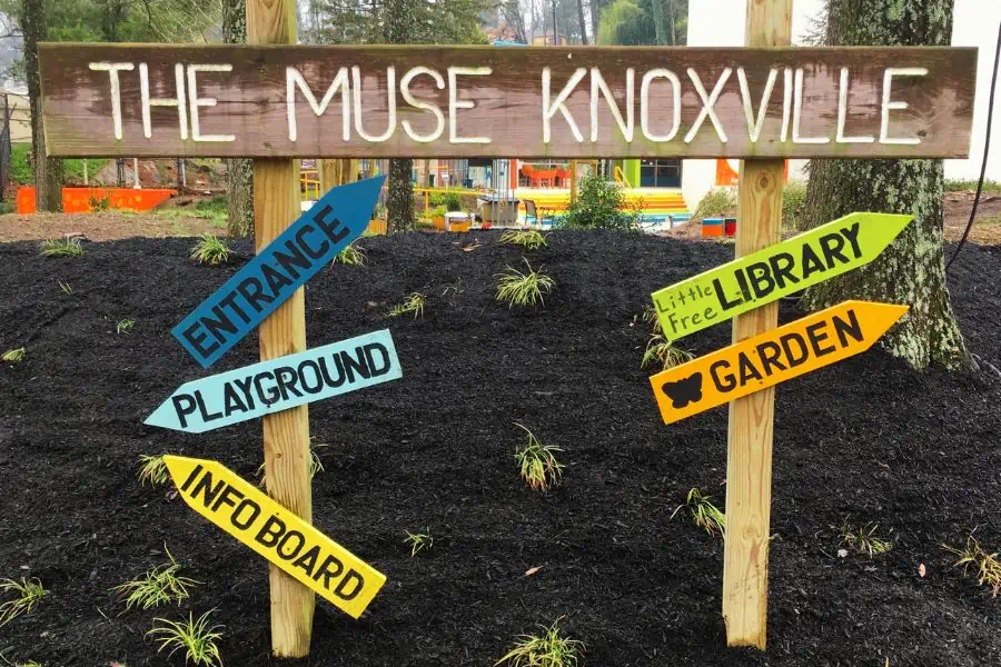 A wooden directional sign at The Miuse children's museum in Knoxville.