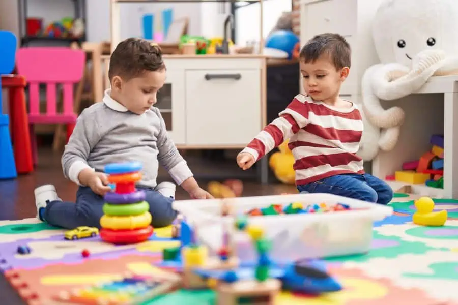 Toddlers in a daycare setting playing togehter with toys.