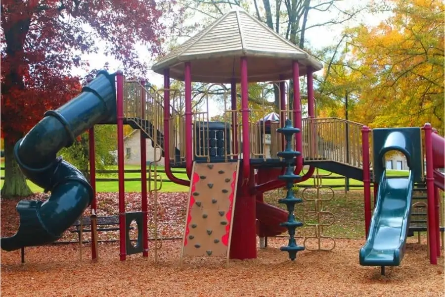large play area with 2 slides, a rock wall, and various climbing structures for kids 