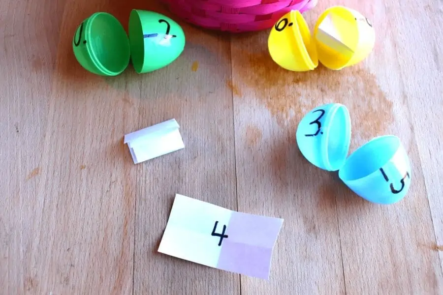 open plastic Easter eggs next to paper number cards