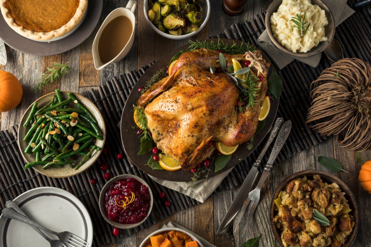 A Thanksgiving table spread with a whole turkey and sides representing prepared Thanksgiving dinners in Knoxville.