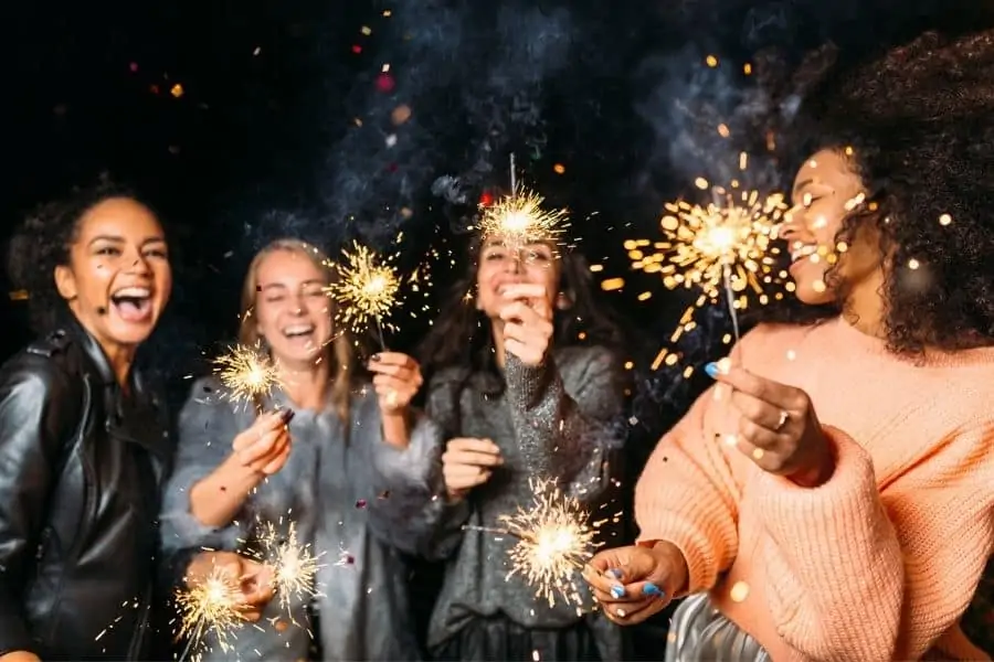 Group of girlfriends with lit sparklers representing New Years fun in Chattanooga