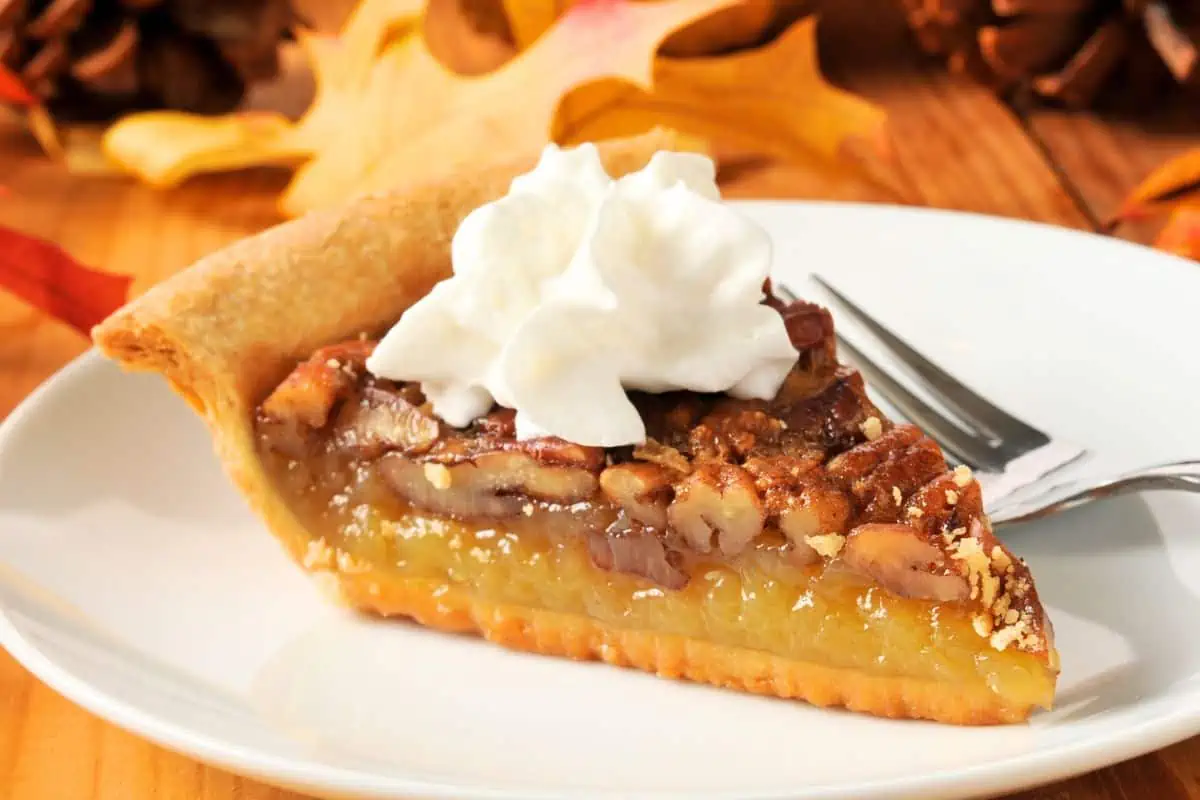 Perfectly baked pecan pie with whipped cream on top representing Chattanooga Restaurants Open Thanksgiving