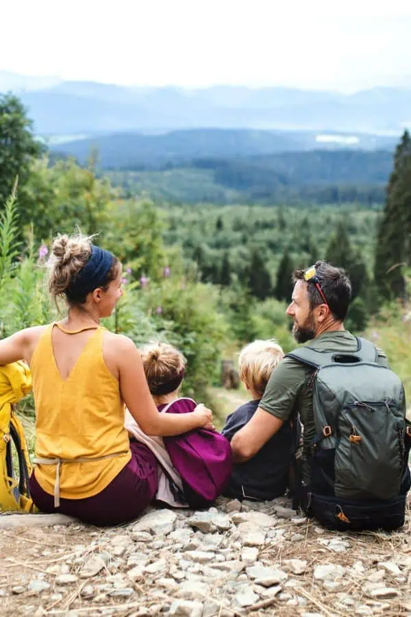 happy family sitting on hiking trail near mountains, representing outdoor activities in Knoxville