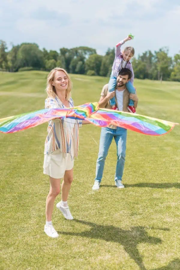 happy family flying kite in field, representing things to do in chattanooga this summer.
