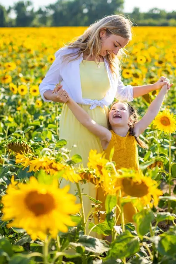 happy mother and daughter standing in  a large sunflower field, representing sunflower fields near Chattanooga.