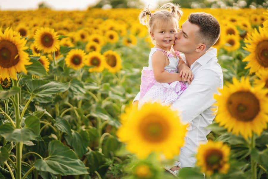 Happy father and daughter hugging in a sunffloer field represeting sunflower fields near Johnson City TN