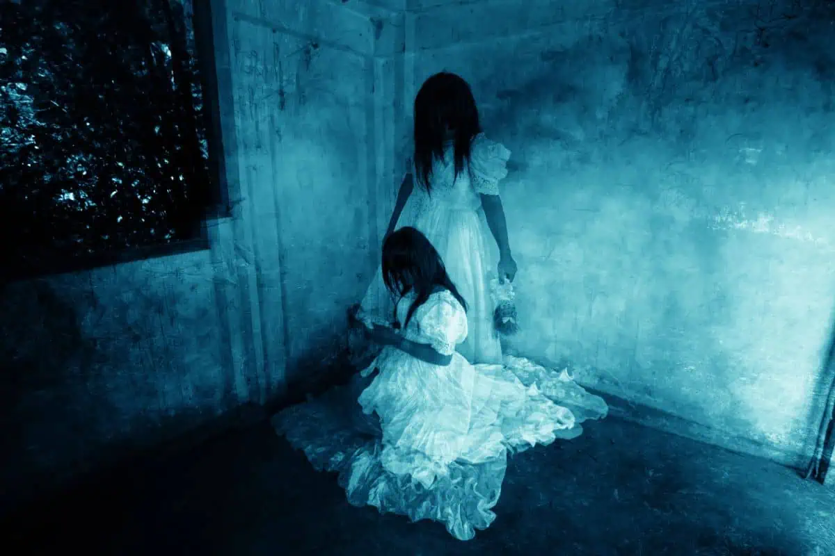 2 ghostly girls huddled in a spooky corner, representing haunted houses in Johnson City TN.